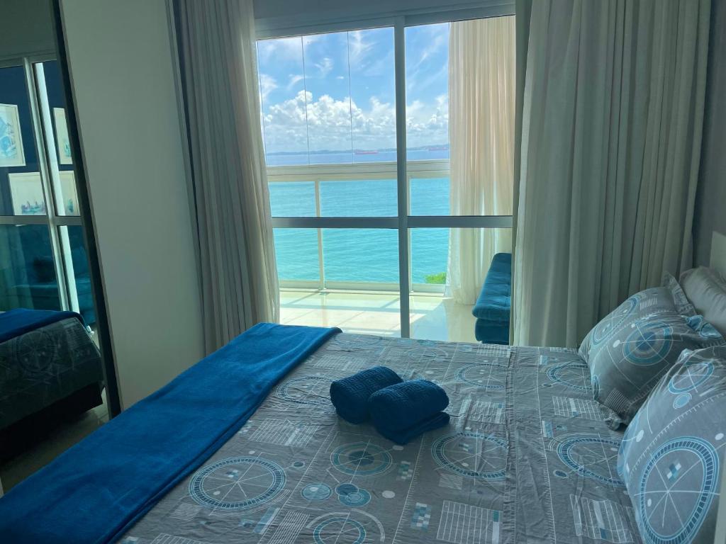 a bedroom with a bed with a view of the ocean at Cloc Marina Vista Mar p/ a Baía de Todos os Santos in Salvador