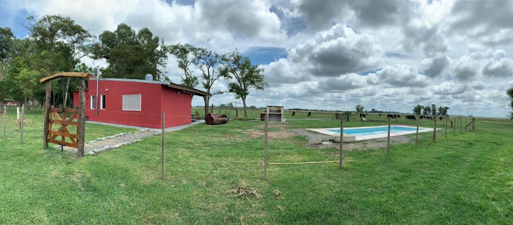 a playground in a field with a small red building at El 24, casa de campo! in Loma Verde