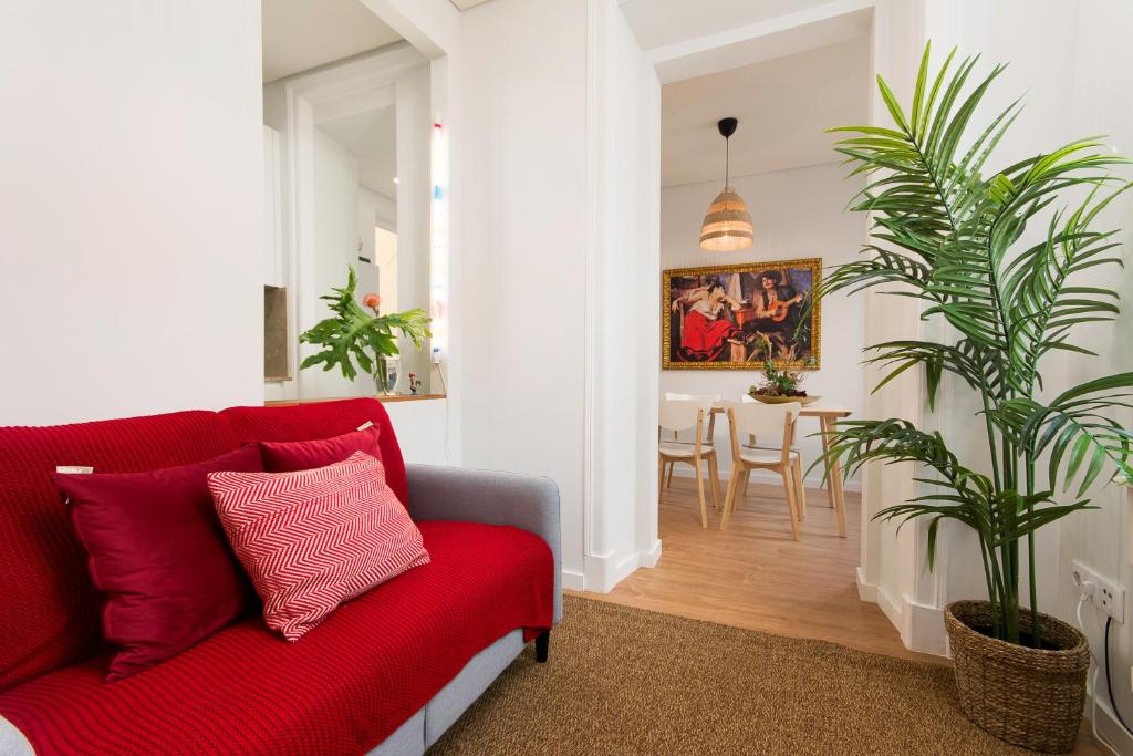 a living room with a red couch and a dining room at Charming Apartment for a Great Stay in Lisbon in Lisbon