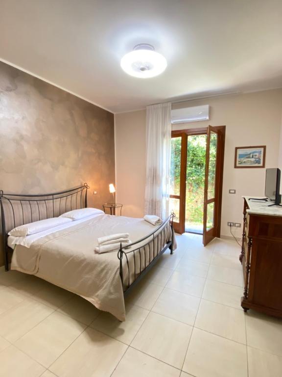 una camera con un letto e una televisione di CILENTO AMMARE VILLA AND ROOMS ad Agropoli