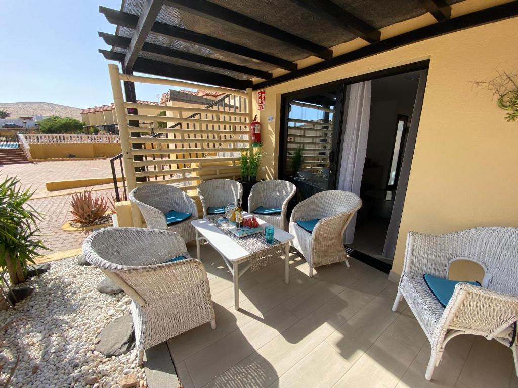 d'une terrasse avec des chaises en osier et une table sur un balcon. dans l'établissement Fuerte Holiday M&M Apartaments 2, à Costa Calma