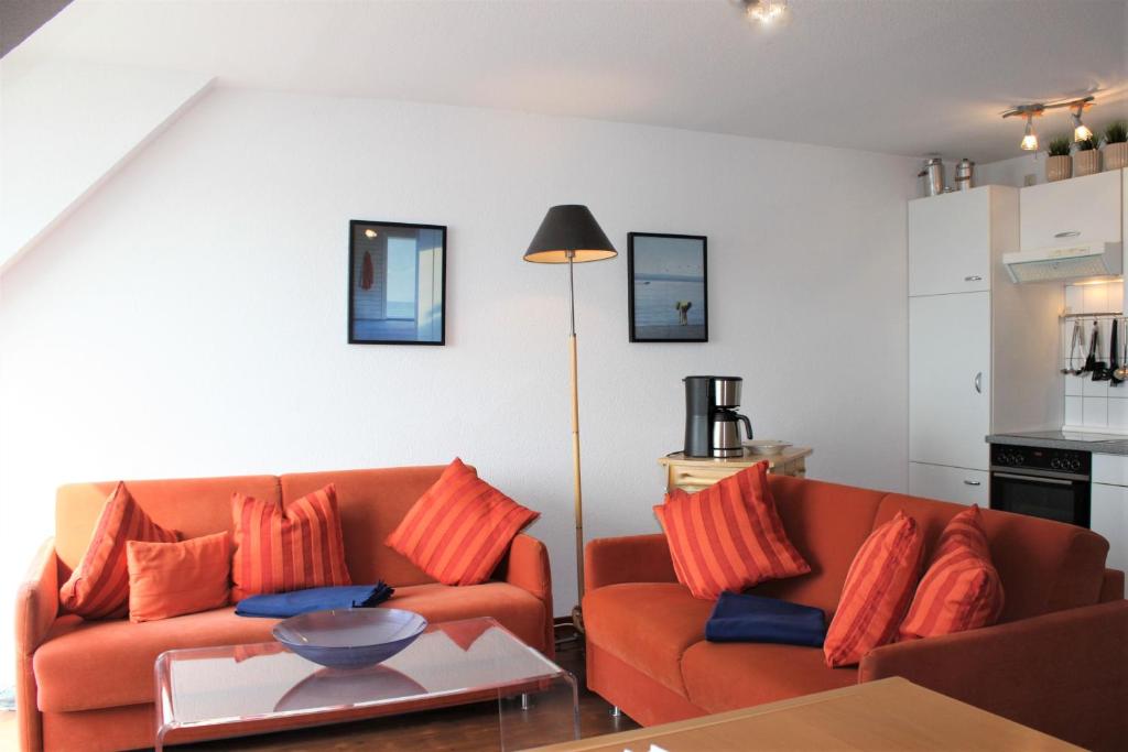 ein Wohnzimmer mit zwei orangenen Sofas und einem Tisch in der Unterkunft Apartment Lüdicke in Kirchdorf