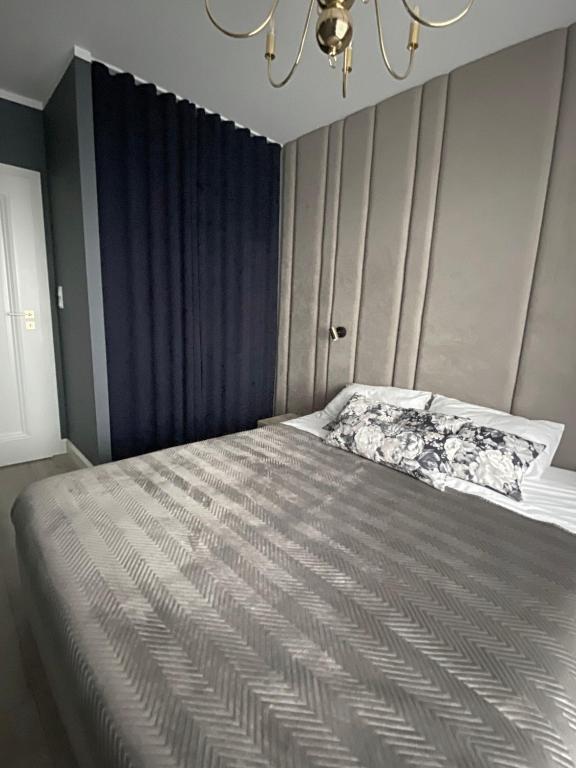 sypialnia z łóżkiem i żyrandolem w obiekcie Apartament Złote Noce w mieście Augustów