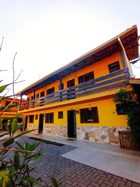 a yellow building with a lot of windows at Diva Surf Quartos in Ubatuba
