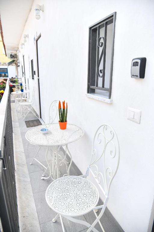 un patio con 2 tavoli, sedie e una finestra di Casa Carolina a Ischia