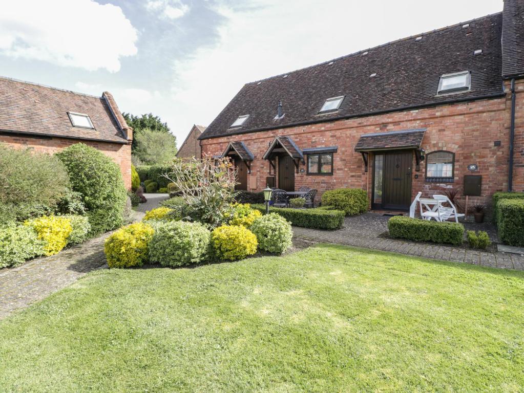 a garden in front of a brick house at Burford Cottage in Weston on Avon