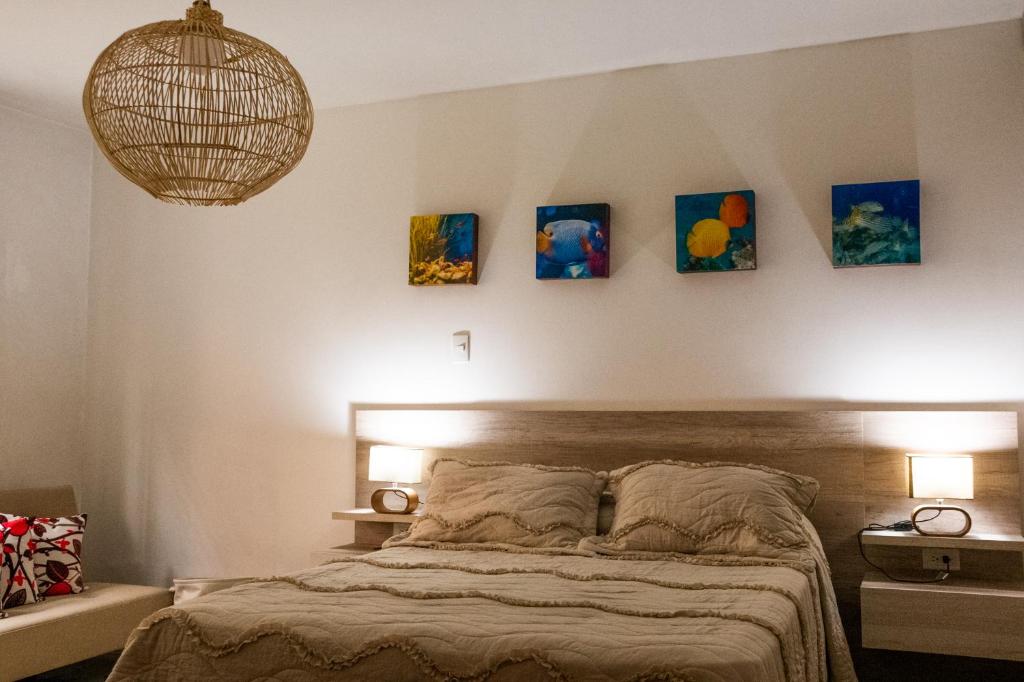a bedroom with a bed with four paintings on the wall at Hotel Casa Esencia in Medellín