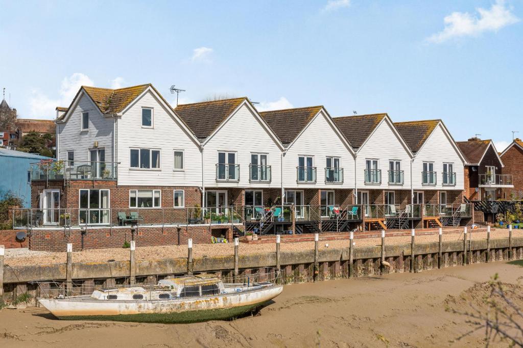 a row of houses and a boat on the water at 16 The Boathouse in Rye