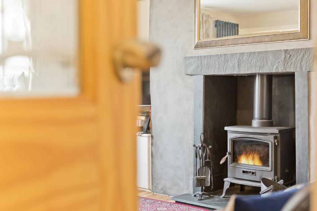 a fireplace with a stove in a room at Harley House in Broughton in Furness
