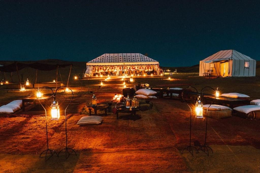 a large building with lights in front of it at night at Camp Sahara berber in Merzouga