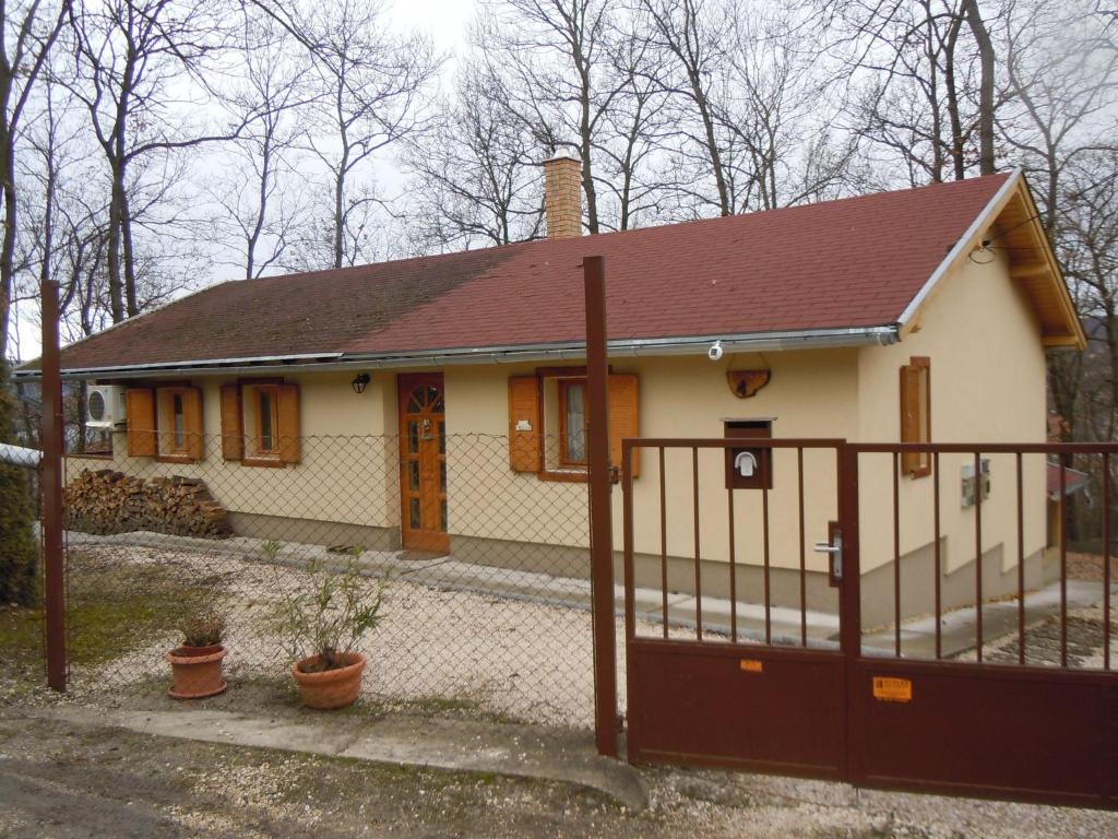 una pequeña casa blanca con techo marrón en E-major en Kismaros
