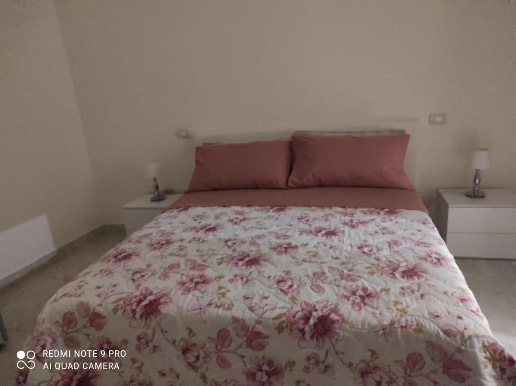 una camera da letto con un letto con copriletto floreale di Casa Fofo' a Napoli