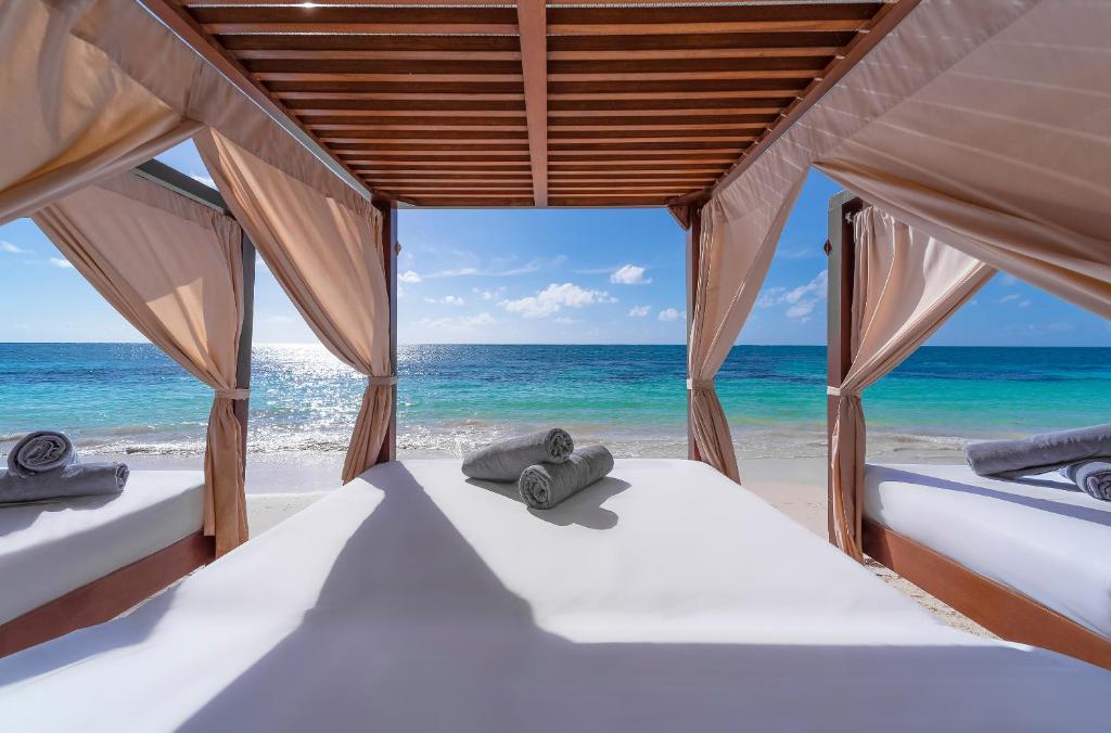 a bedroom with two beds on the beach at Desire Riviera Maya Resort All Inclusive - Couples Only in Puerto Morelos