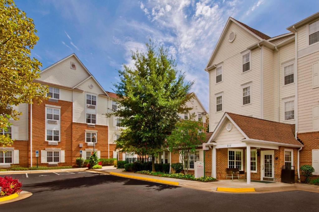 a row of apartment buildings with a tree at Sonesta Simply Suites Falls Church in Falls Church