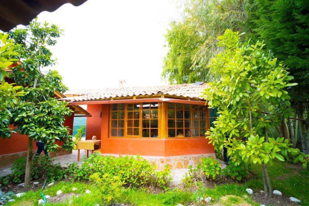 a small house with orange walls and windows at Bungalow Cajamarca, con Wifi y Cochera in Cajamarca