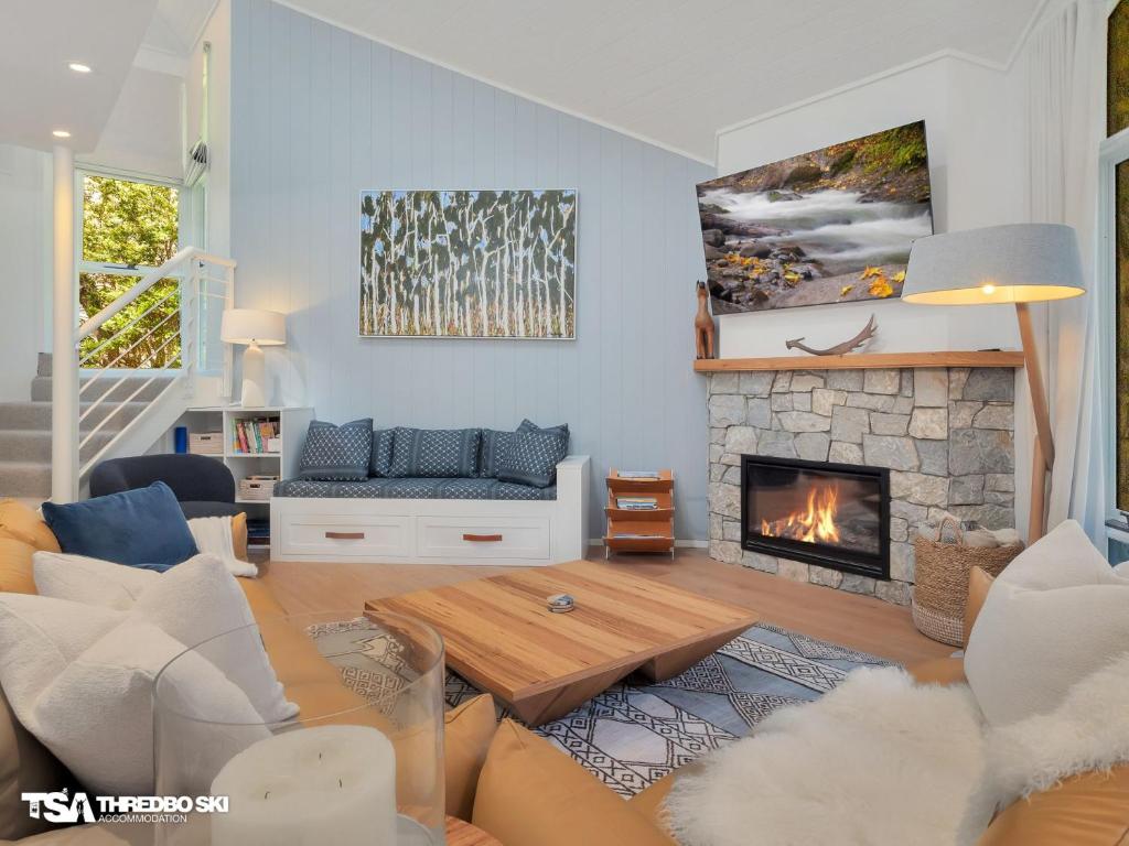 a living room with a couch and a fireplace at Stepping Stone in Thredbo