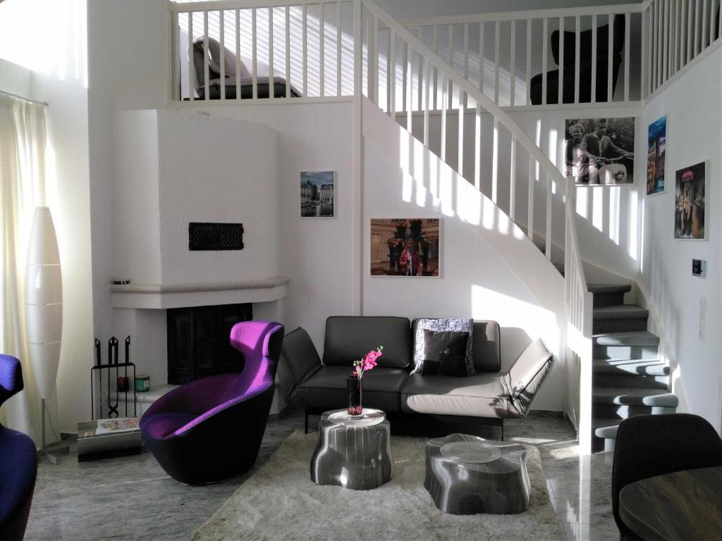 a living room with a couch and a staircase at Am Seehof in Sierksdorf