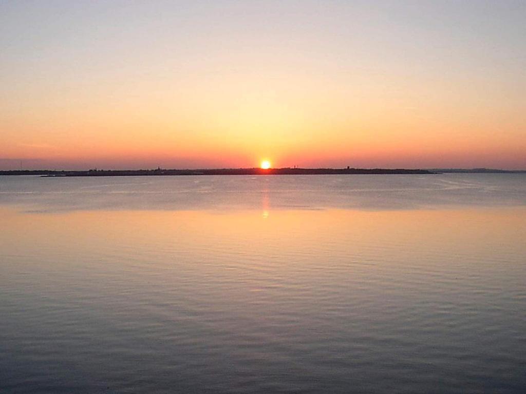 een zonsondergang boven een grote hoeveelheid water bij Holiday home Vestervig XXXIII in Vestervig