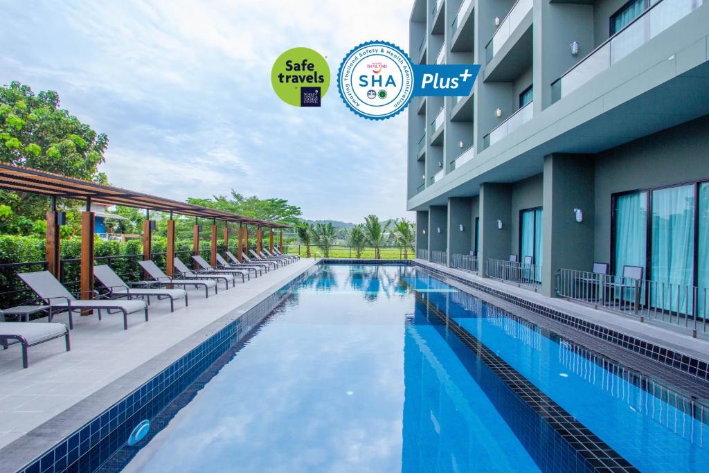 a swimming pool at the side of a hotel at Sugar Marina Hotel -AVIATOR- Phuket Airport - SHA Extra Plus in Nai Yang Beach