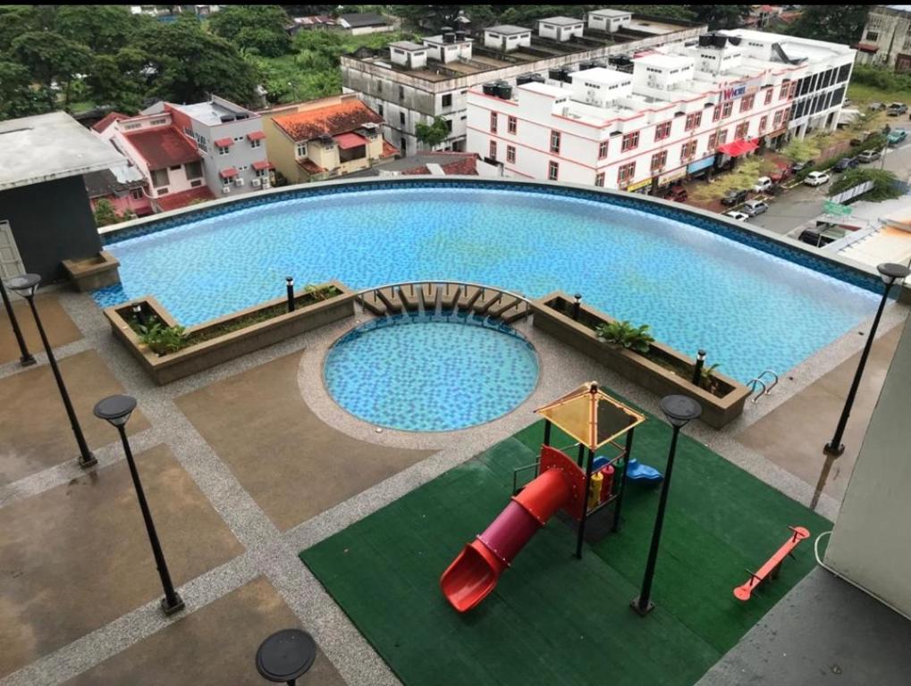 an overhead view of a large swimming pool with a slide at Homestay Apartment KB @ D'perdana Condo in Kota Bharu
