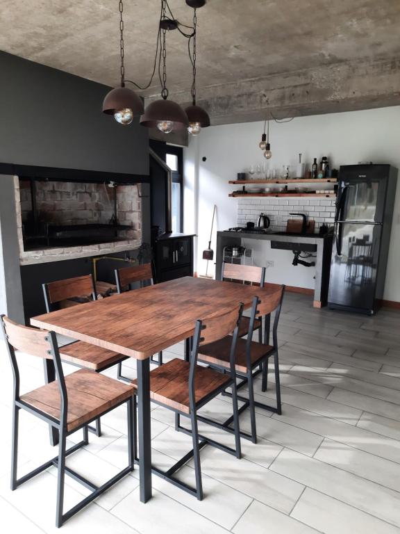 uma sala de jantar com uma mesa de madeira e cadeiras em Casa de Invitados con Parrilla y horno a leña em Ushuaia