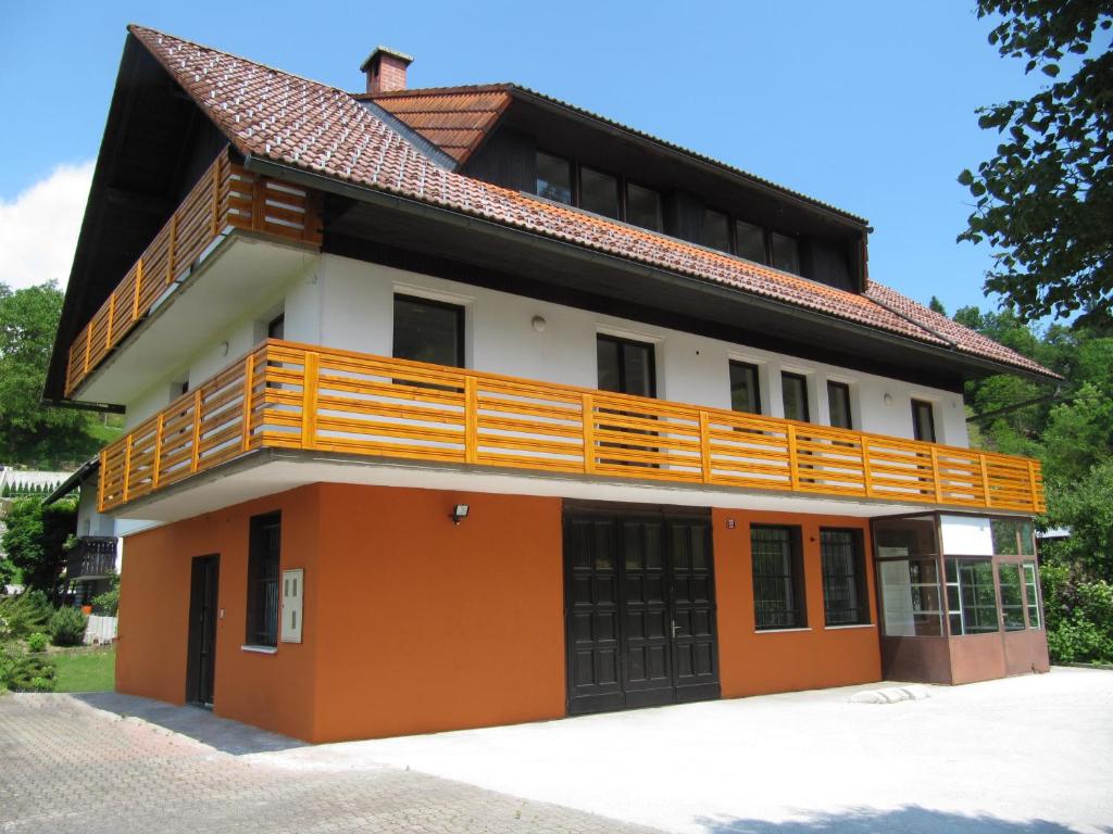 an orange and white building with a balcony at Apartments Lipa in Železniki
