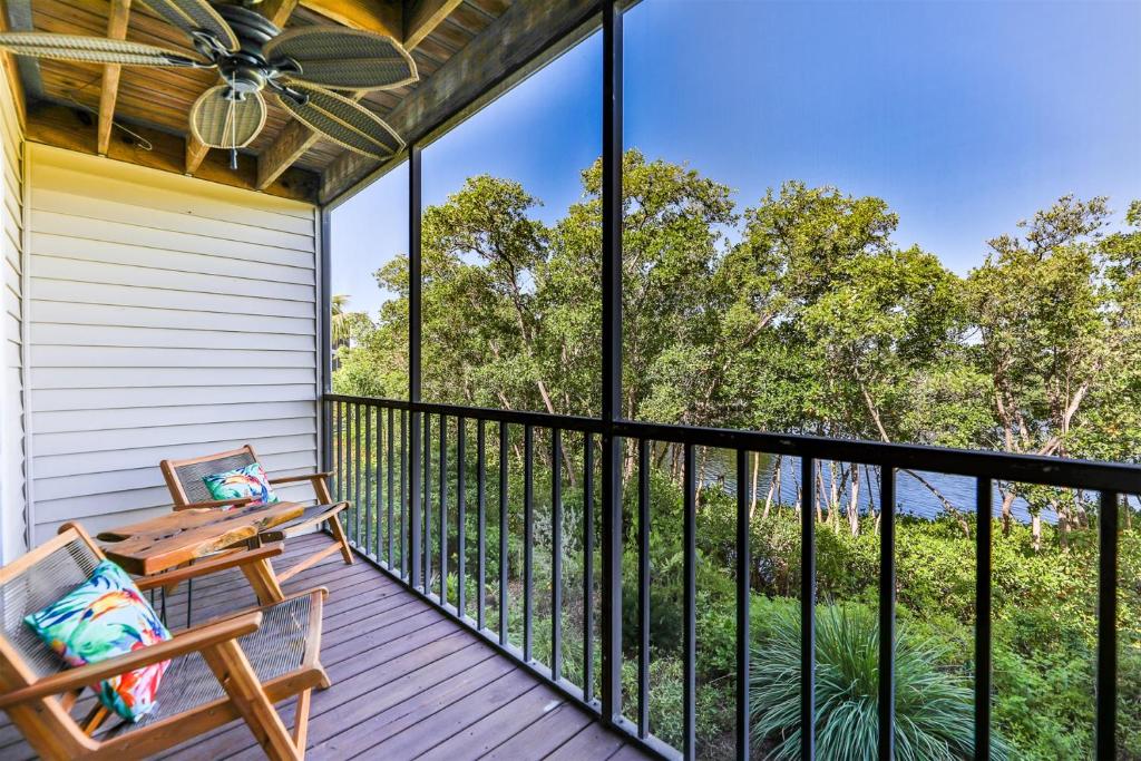a screened porch with a chair and a ceiling fan at Lake Palms 7 in Sanibel