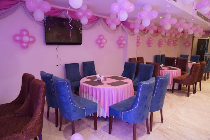 a room with tables and chairs and a television and balloons at Hotel West End View in Zirakpur