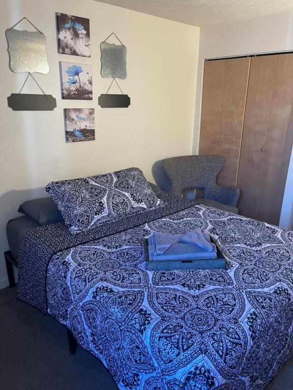 a bedroom with a bed with a blue blanket and a chair at Have At It , University City, Smart Tv, Free Street Parking, Zip Car Site in Philadelphia