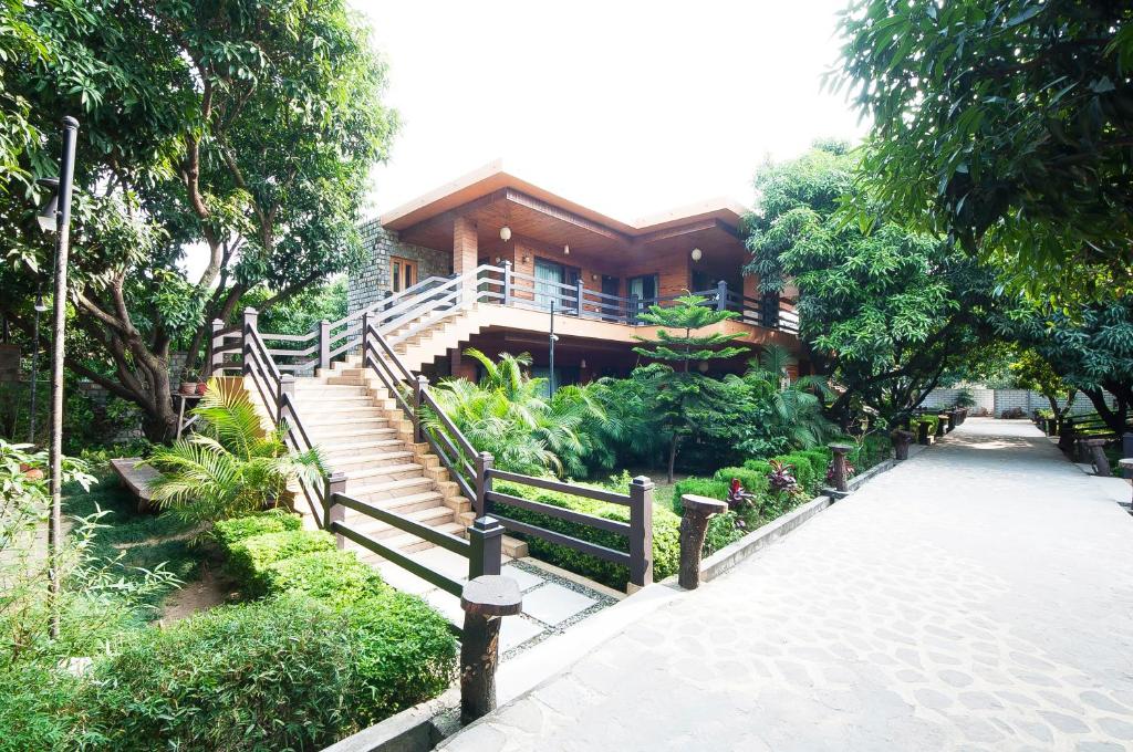 a house with a staircase in front of it at Tuskars Riverside Resort Jim Corbet in Rāmnagar