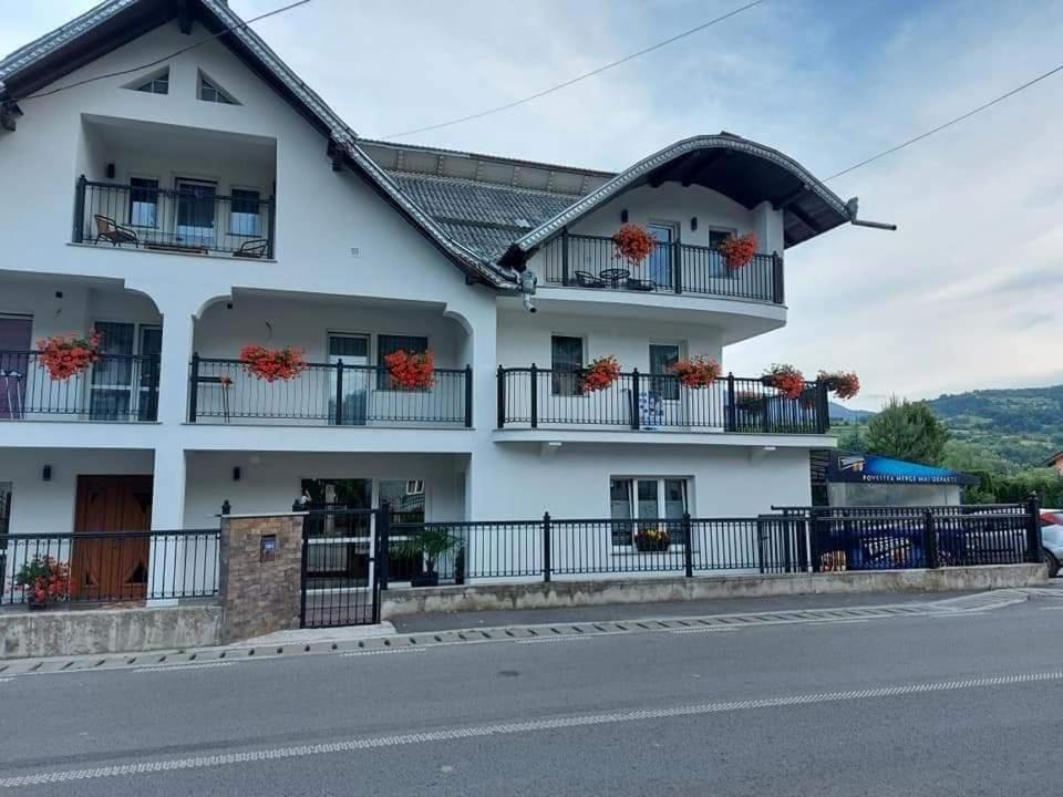 a white house with balconies on a street at Casa MYM in Moisei