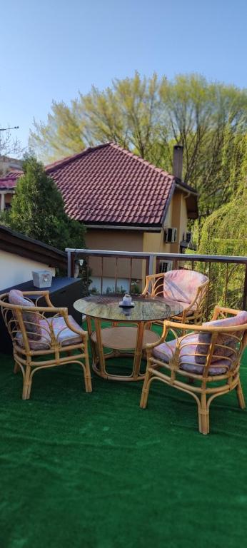 un patio con una mesa y sillas en el césped en Мансардна Никол en Vidin