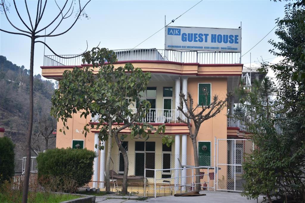 a guest house with a sign on top of it at AJK Guest House in Muzaffarabad