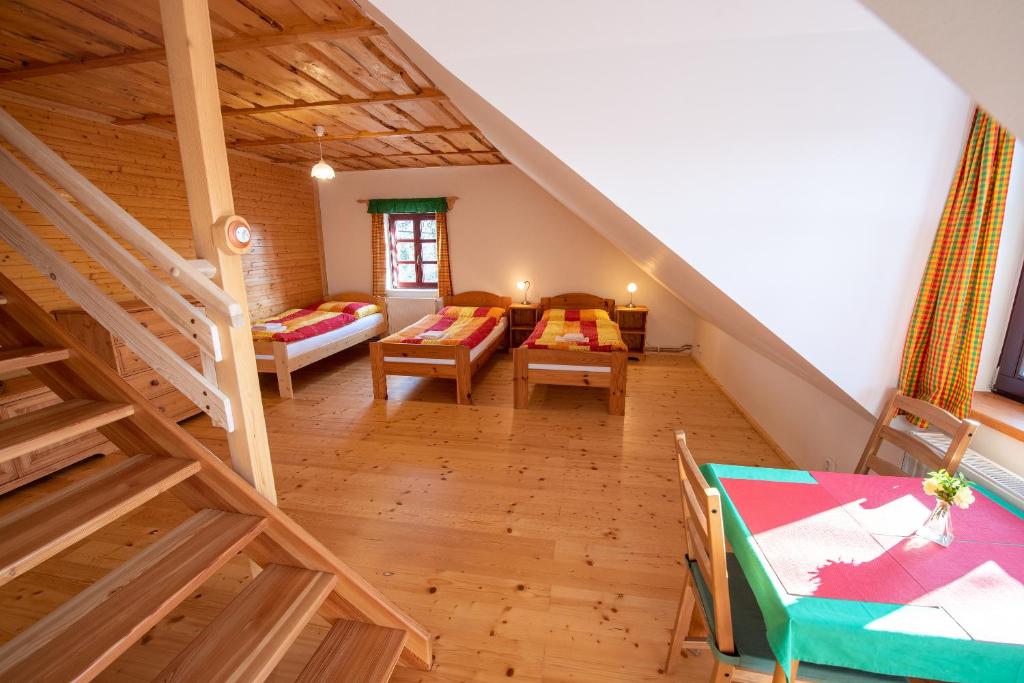ein Dachzimmer mit einer Treppe, einem Tisch und Stühlen in der Unterkunft Ubytování U nás doma in Baška