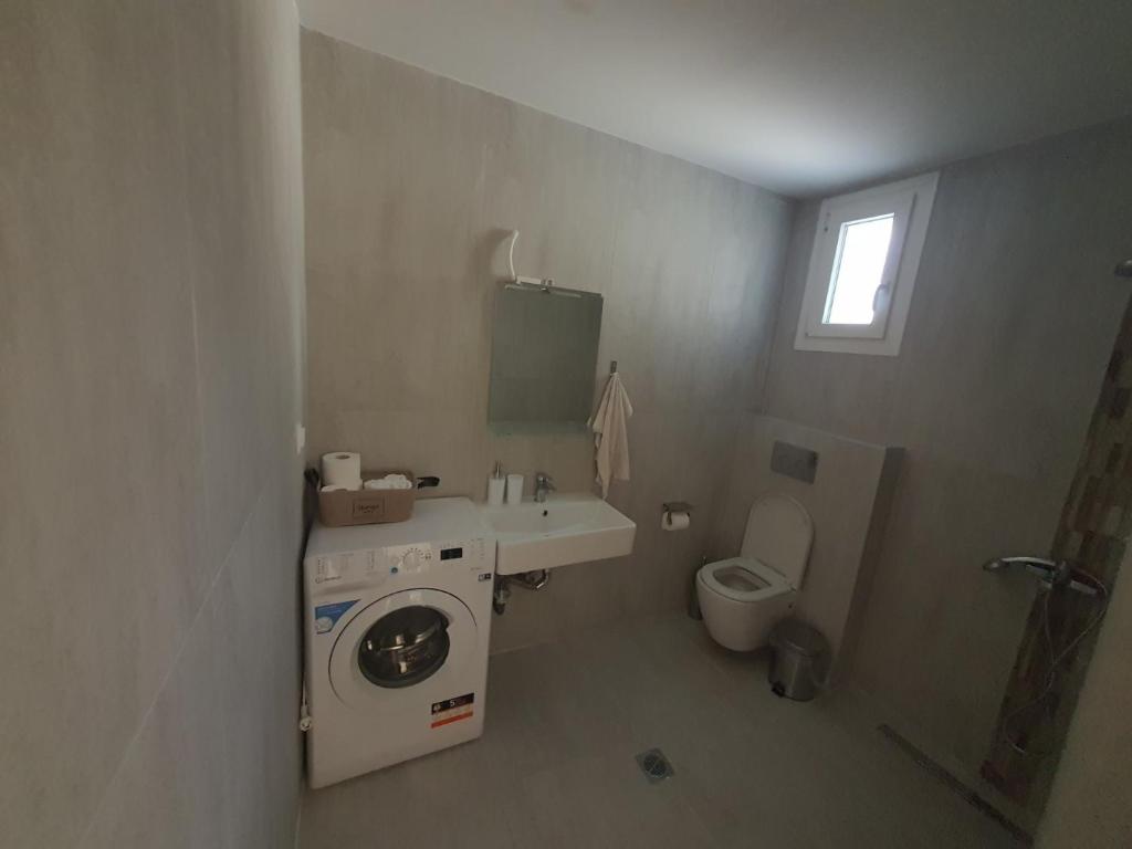 W łazience znajduje się pralka i umywalka. w obiekcie New apartment ,50m from the sea at Nea Irakleia. w mieście Nea Iraklia