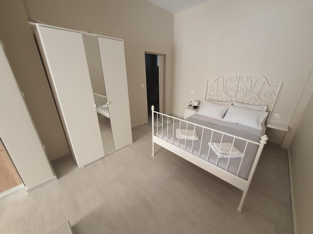 małą sypialnię z łóżkiem i lustrem w obiekcie New apartment ,50m from the sea at Nea Irakleia. w mieście Nea Iraklia