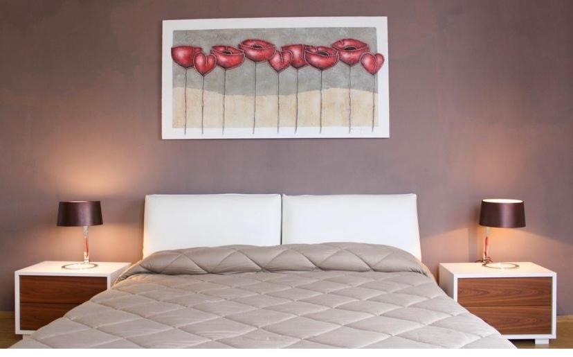 Il MonteにあるPorto Gaio Accomodationのベッドルーム1室(ベッド1台、ランプ付きテーブル2台付)