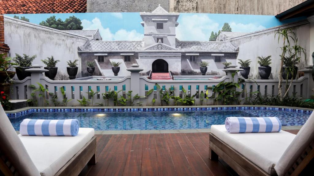 a house with a swimming pool with two beds at Kutus Kutus Omah Siliran Heritage in Yogyakarta