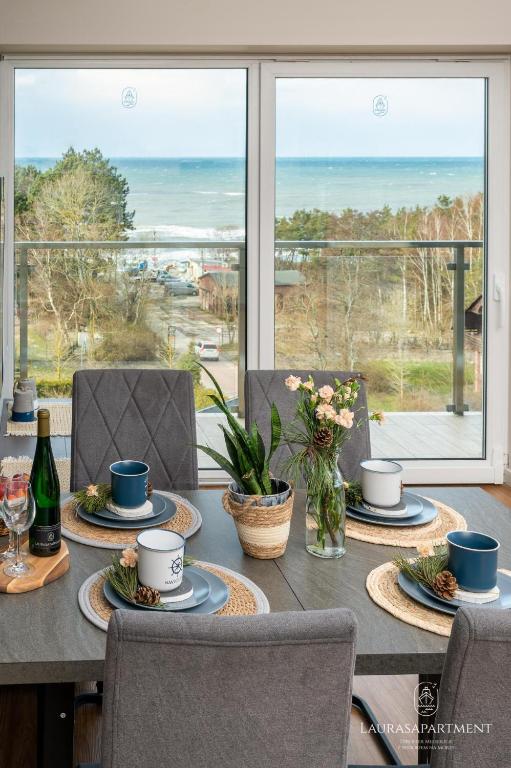 a dining room table with a view of the ocean at Laurasapartment in Jarosławiec