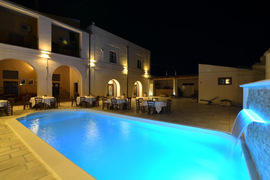 a swimming pool in front of a building at night at Agriturismo Masseria Santa Lucia al Bradano in Matera