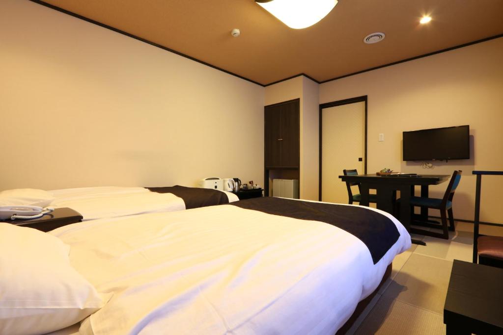 Postel nebo postele na pokoji v ubytování Masuya Ryokan