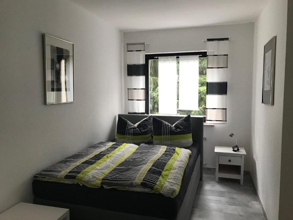 Un dormitorio pequeño con una cama y una ventana. en Ferienwohnung Wintergarten, en Bad Pyrmont