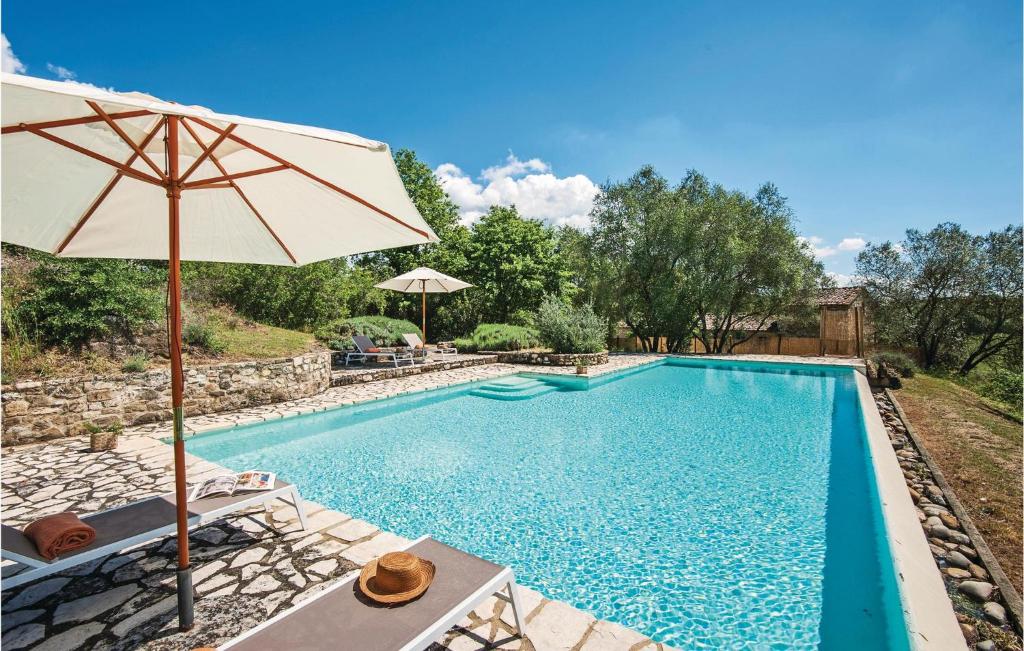 a swimming pool with an umbrella and chairs and a table with an umbrella at Santantimo in Castellina in Chianti