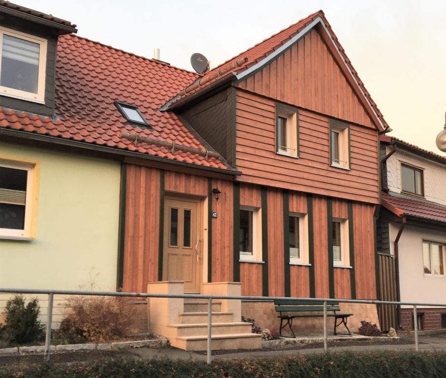 a wooden house with a bench in front of it at Ferienwohnung - Haus Molle in Benneckenstein