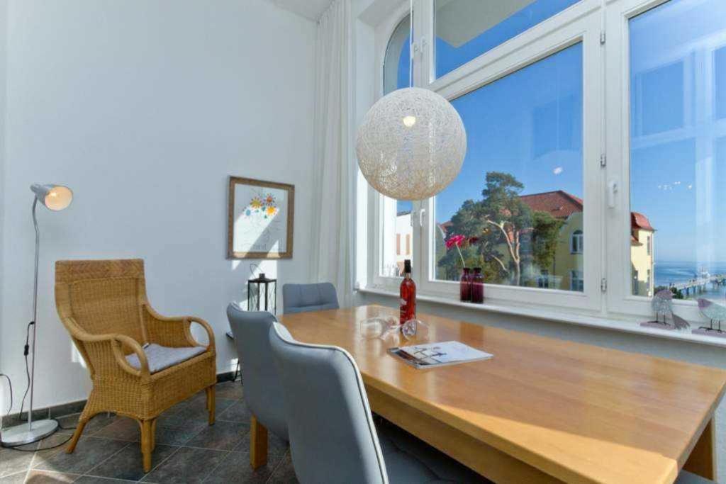 ein Esszimmer mit einem Tisch und einem großen Fenster in der Unterkunft Villa Carola, App 7 in Bansin
