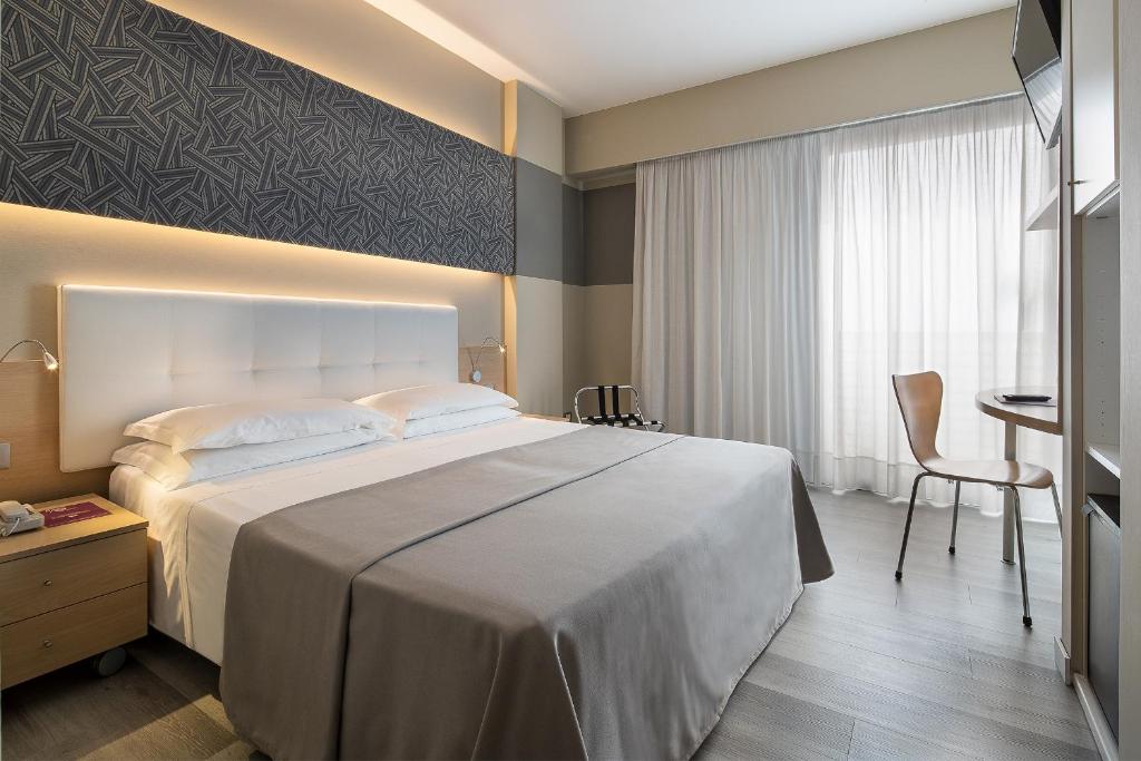 Hotel Rosanna 3 Stelle Superior في ليدو دي يسولو: غرفة نوم بسرير كبير ومكتب
