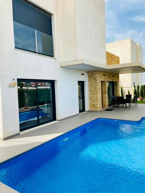 a swimming pool in front of a house at Luxury villa with private pool in Rojales