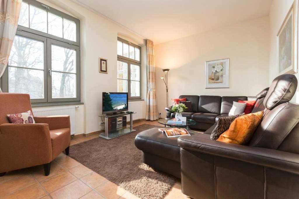 uma sala de estar com um sofá de couro e uma televisão em Villa San Marino, App 7 em Heringsdorf