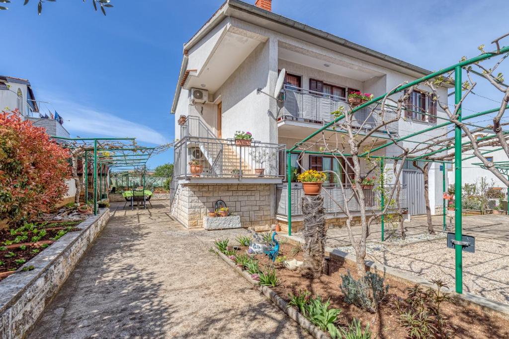 a house with a garden in front of it at Apartment Mirijana in Tar