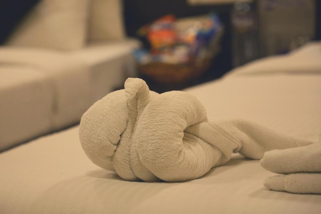 un animal de serviettes est posé sur un lit dans l'établissement Hotel Blue Mystic, à Pune